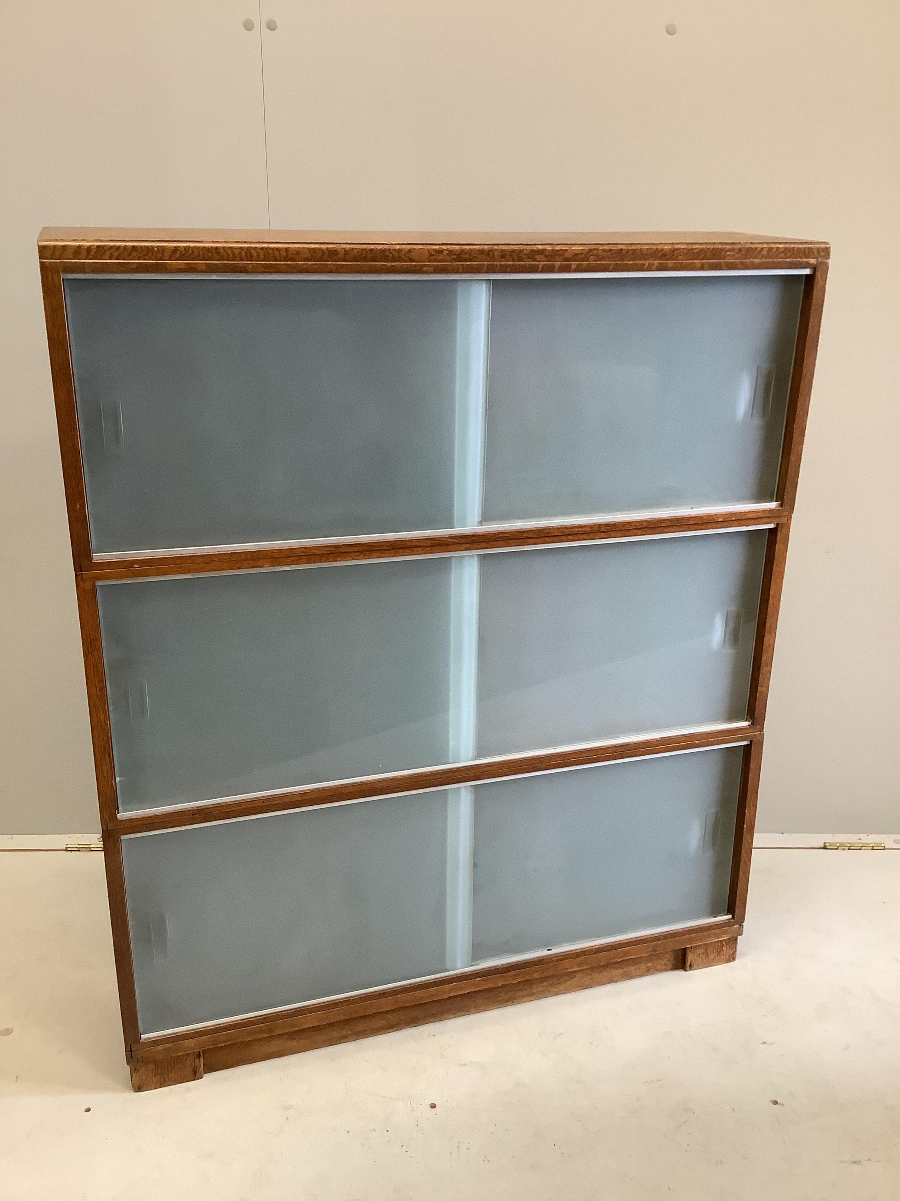 A three section Minty oak bookcase, width 89cm, depth 23cm, height 104cm